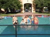 group of seven adults in pool facing camera