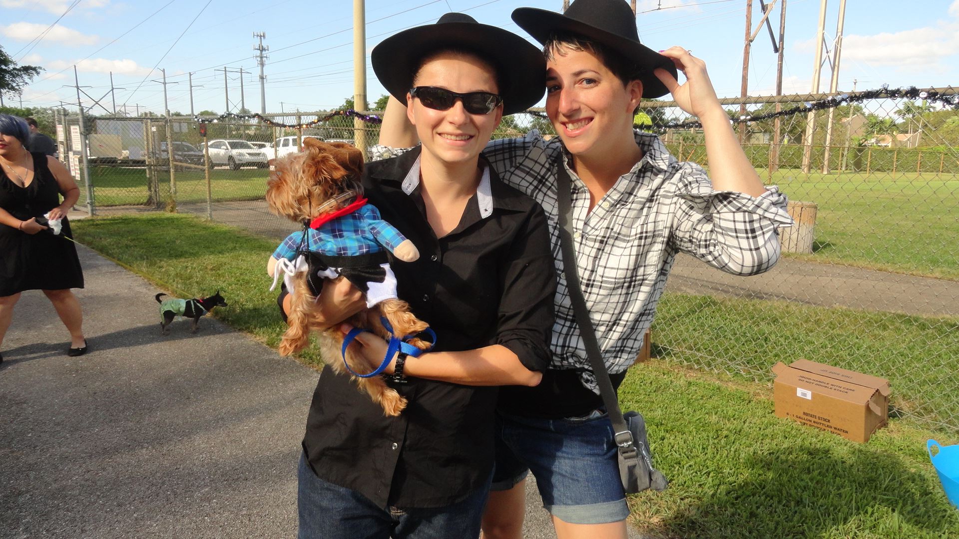 2 ladies dressed in their country attire with their little dog in cowboy outfit