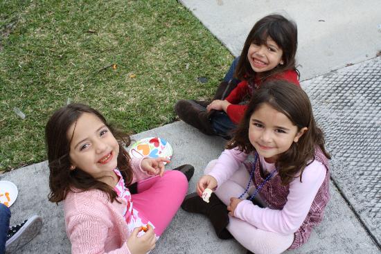 Little girls sitting on a sidewalk